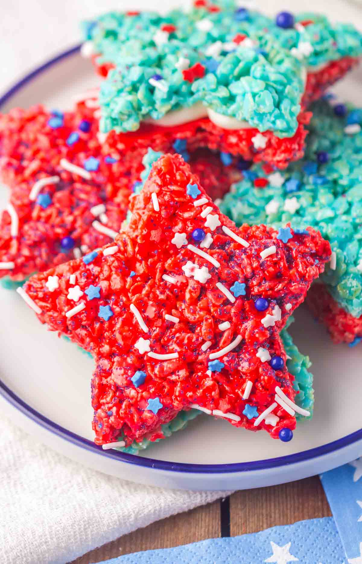 A plate with star-shaped Patriotic Rice Crispy Treats, decorated with white, red, and blue sprinkles.