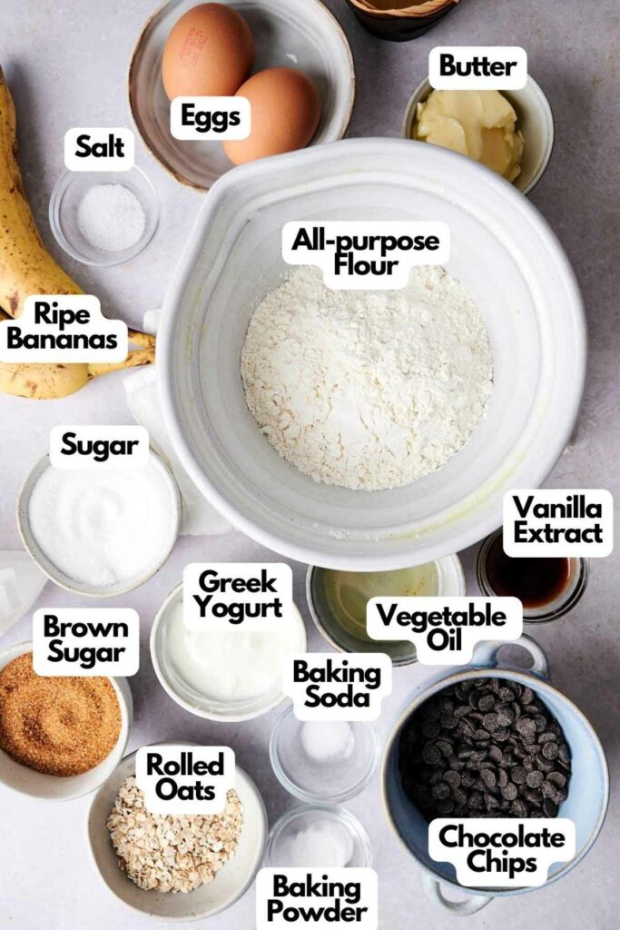 Ingredients for banana chocolate chip muffins, including ripe bananas, eggs, butter, salt, all-purpose flour, vanilla extract, sugar, brown sugar, Greek yogurt, vegetable oil, baking soda, rolled oats, baking powder, and chocolate chips.