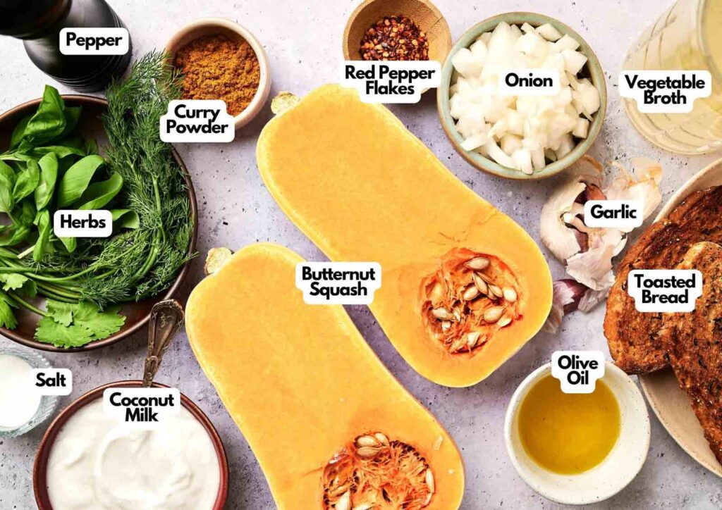 Labeled ingredients for Butternut Squash Soup are arranged on a counter, including squash, spices, herbs, broth, bread, coconut milk, olive oil, onion, and garlic.