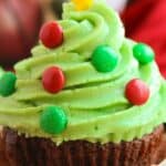 A chocolate cupcake with green frosting, decorated with red and green candies, perfect for festive Christmas tree cupcakes.