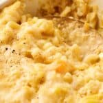 Close-up of a creamy, butternut squash mac and cheese with a golden crust, sprinkled with black pepper.