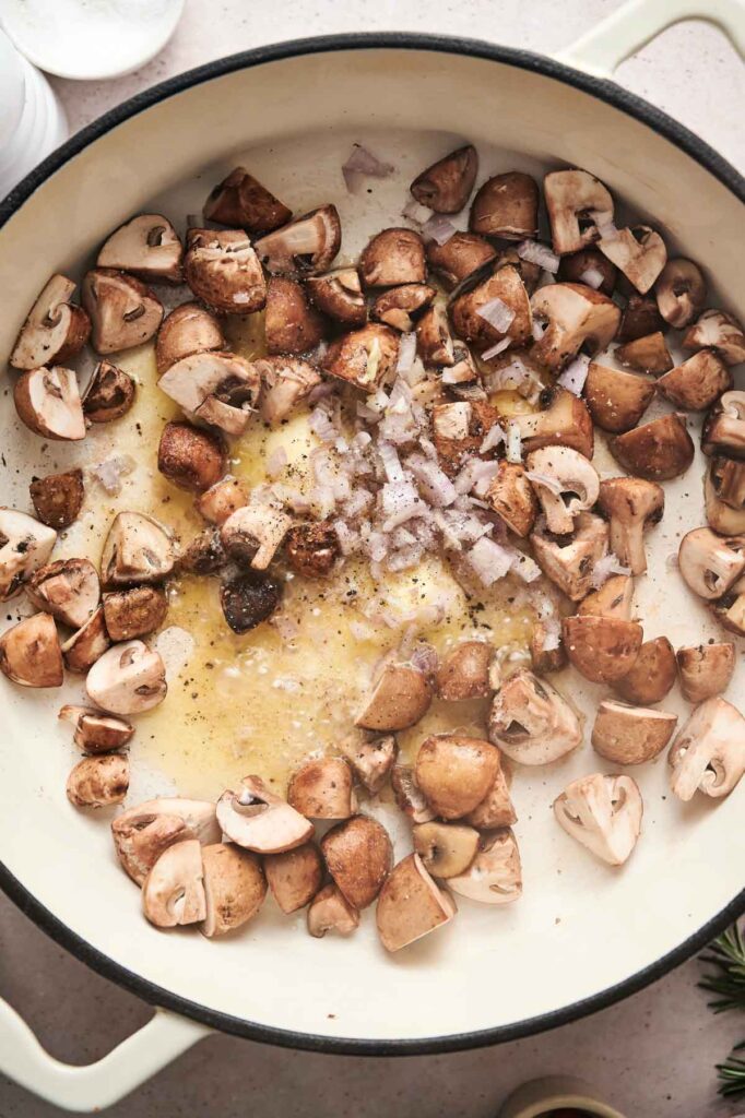 Mushrooms and chopped onions sizzle in a pan with butter and seasonings, creating the perfect base for a delectable mushroom pasta.