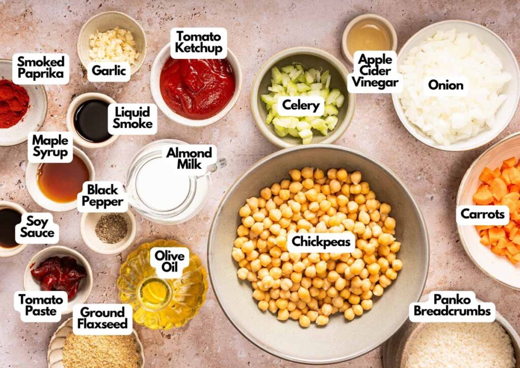 Various labeled ingredients for a recipe, including chickpeas, vegetables, spices, and condiments, are displayed in bowls on a countertop&mdash;perfect essentials for preparing a delicious Vegetarian Meatloaf.