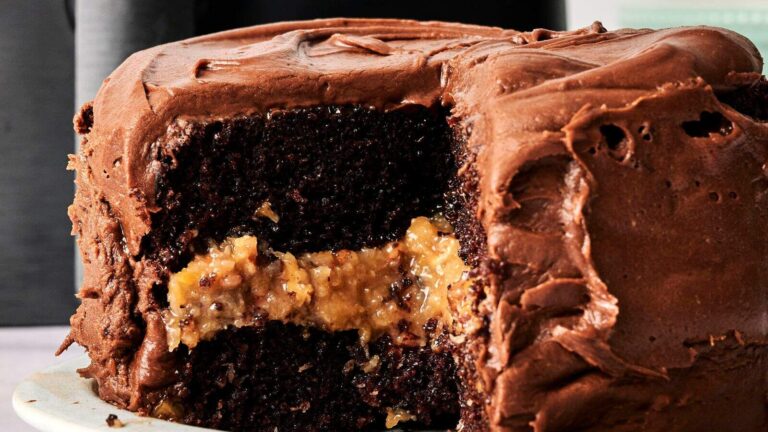 A chocolate layer cake with chocolate frosting, sliced to reveal a coconut and pecan filling.