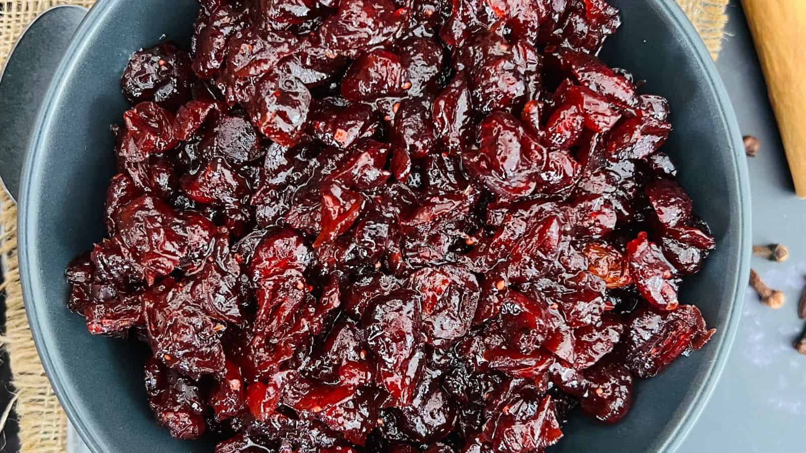 A close-up of a bowl filled with dark red cranberry sauce.
