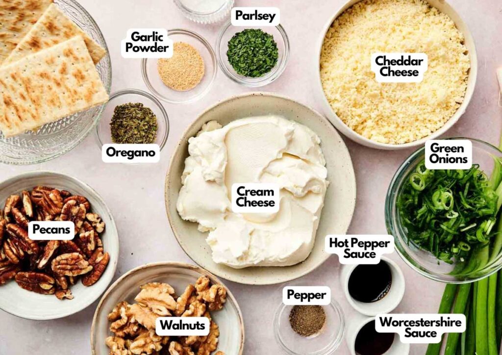 A variety of labeled ingredients in bowls for a classic Cheese Ball, including cream cheese, cheddar cheese, green onions, walnuts, pecans, spices, hot pepper sauce, Worcestershire sauce, and crackers.