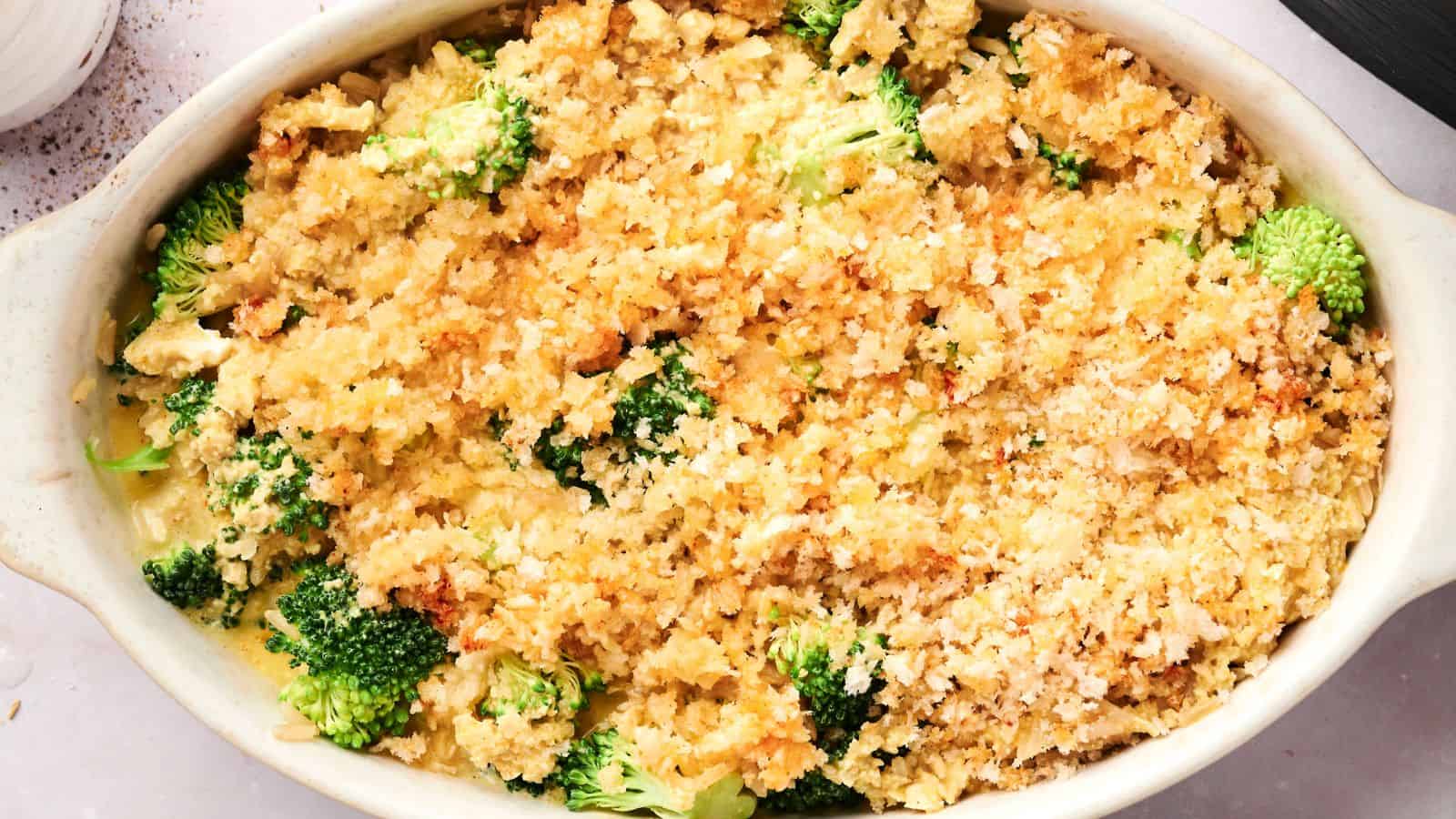 A casserole dish filled with broccoli casserole topped with golden, crispy breadcrumbs.